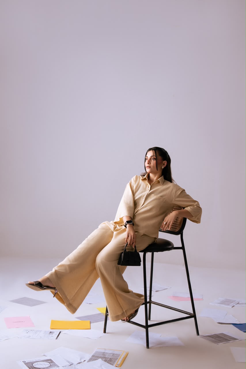 The Slow Season Shirt & Easy Escape Trousers – seated close-up with bag
